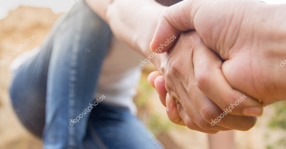 People helping each other hike up a mountain, Giving a helping hand, and active fit lifestyle concept.